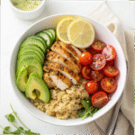 Grilled chicken served over quinoa with avocado, tomatoes, and fresh vegetables