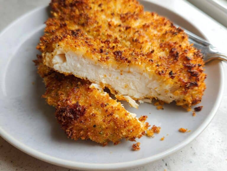 Cross-section of Air Fryer Parmesan Crusted Chicken Breasts showing juicy white meat and crispy golden coating.