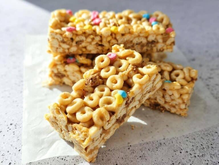 Close-up of stacked Peanut Butter Banana Cheerio Bars featuring cereal rings and colorful marshmallows.
