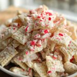 Close-up of White Chocolate Peppermint Chex Mix coated in white chocolate and topped with crushed candy canes.