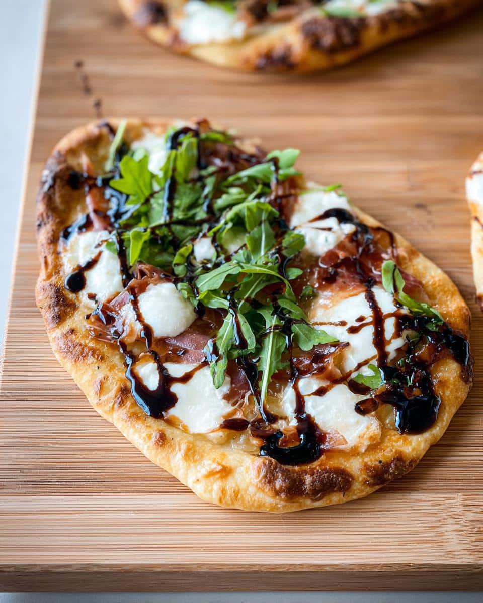 Close-up of a delicious 5-Ingredient Flatbread Pizza topped with fresh mozzarella, prosciutto, arugula, and balsamic glaze.