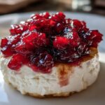 A single serving of Cranberry-Cinnamon Goat Cheese Bites topped with glistening cranberry relish on a white plate.