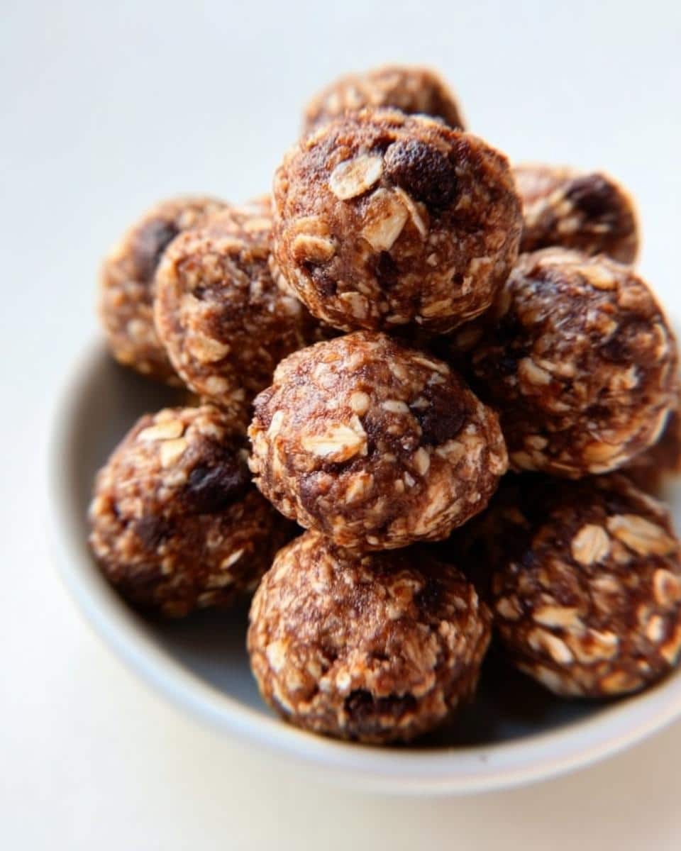Close-up of a stack of homemade Peanut Butter Chocolate Energy Bites, showing visible oats and chocolate chips.