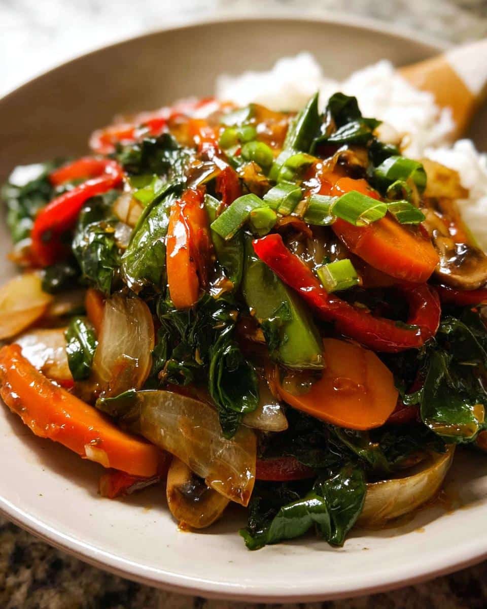 A close-up of a vibrant Vegetable Stir Fry with Light Sauce served over white rice, topped with green onions.
