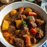 Close-up of rich Beef Stew With Root Vegetables featuring tender beef chunks, potatoes, and carrots in a savory brown sauce.