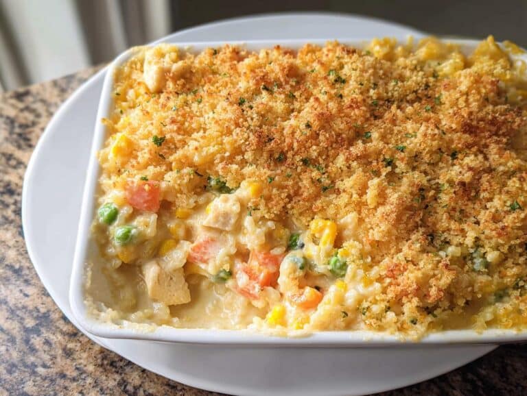 A close-up of a baked Creamy Chicken and Rice Casserole with a golden, crunchy breadcrumb topping.