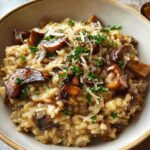 A close-up of a rich, creamy mushroom risotto topped with sautéed mushrooms, grated Parmesan, and fresh parsley.