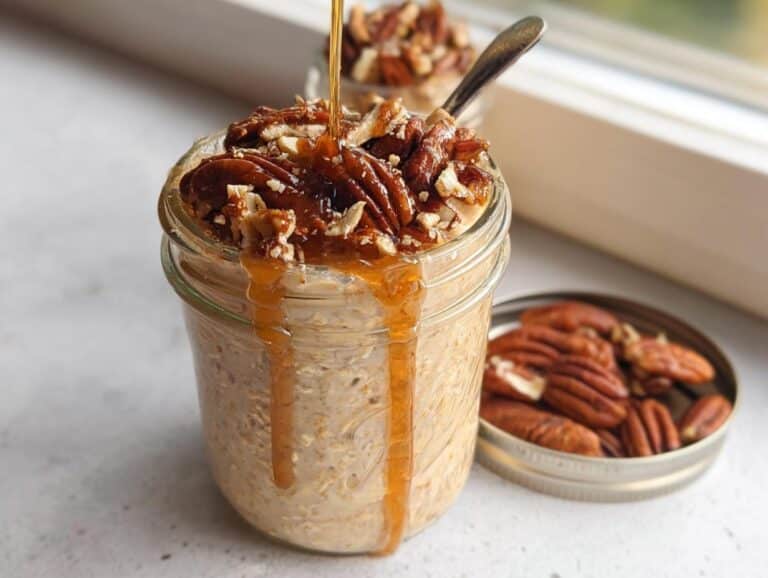 A jar of Maple Pecan Overnight Oats topped with pecans and drizzled with maple syrup.